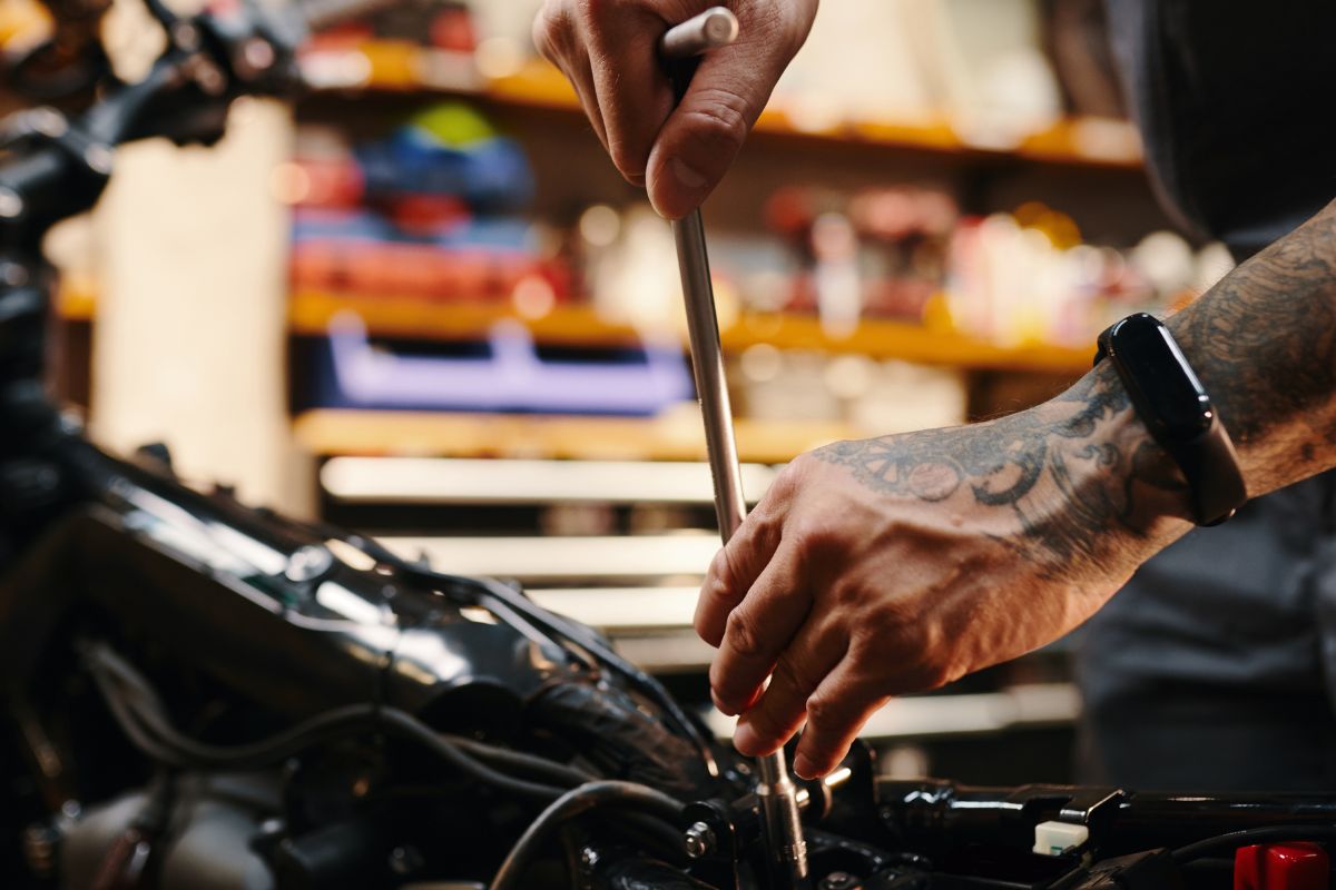 A picture of someone fixing a motorcycle.