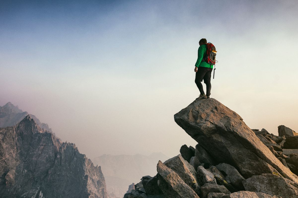 A picture of someone at the summit of a mountain.