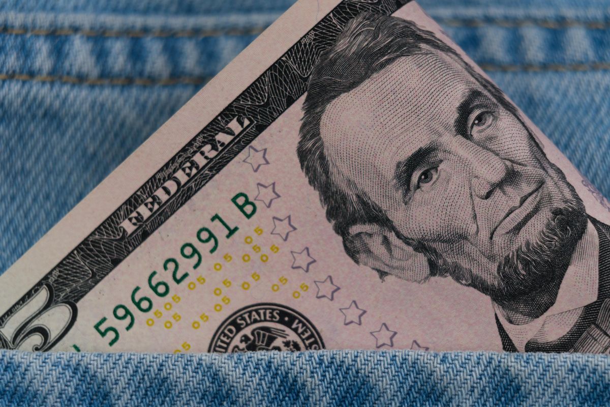 A picture of $5 bill on a pocket.