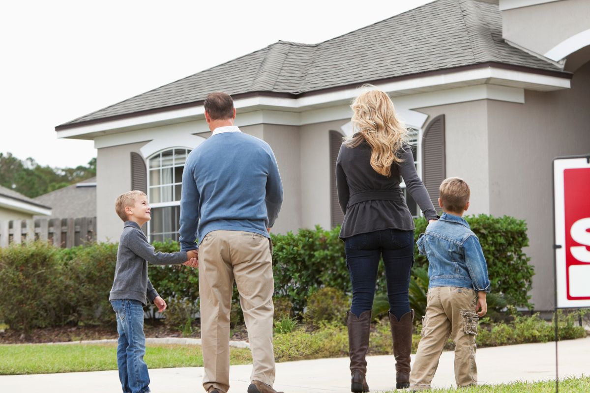 A picture of a family walking to a house.