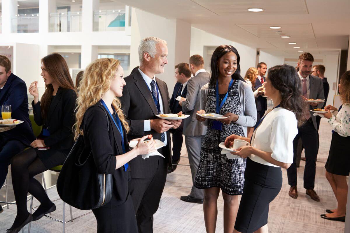 A picture of businessmen and businesswomen talking to each other.