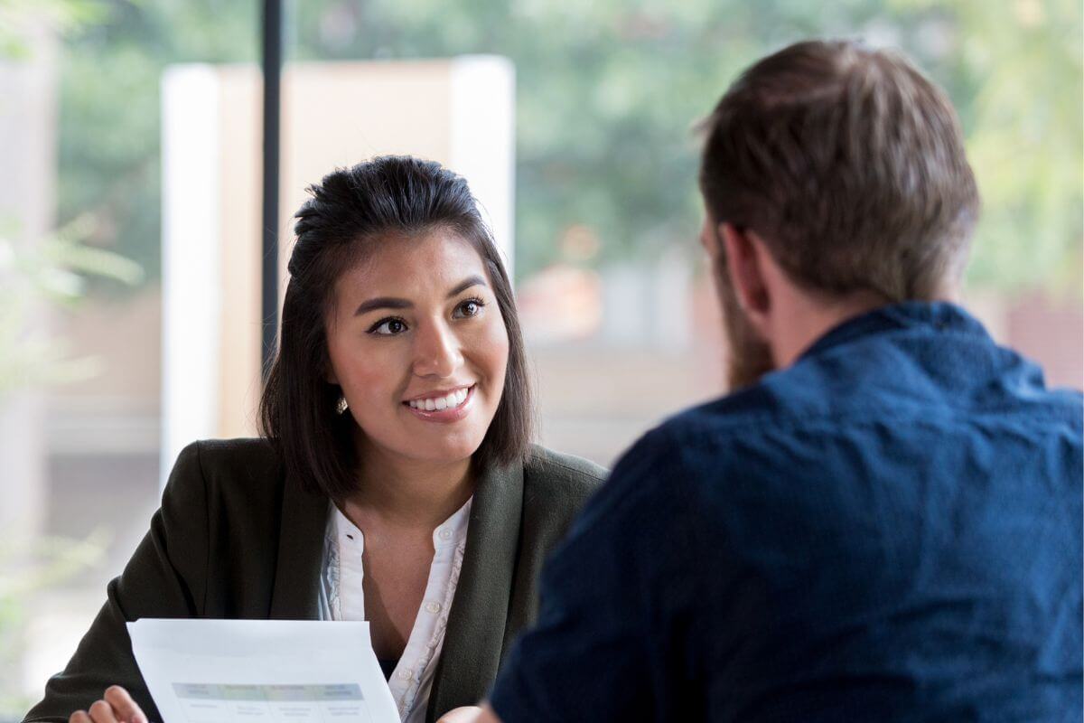 A picture of someone talking to a bank representative. 
