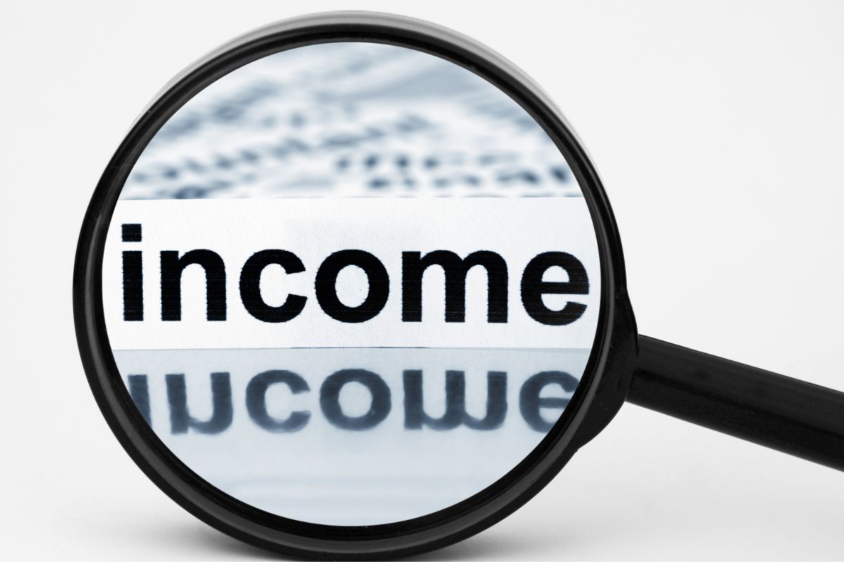 An image of a magnifying glass with income wording.