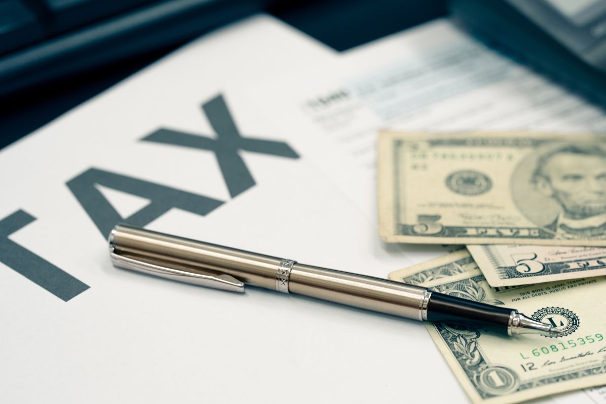 A picture of money and a paper with tax wording.