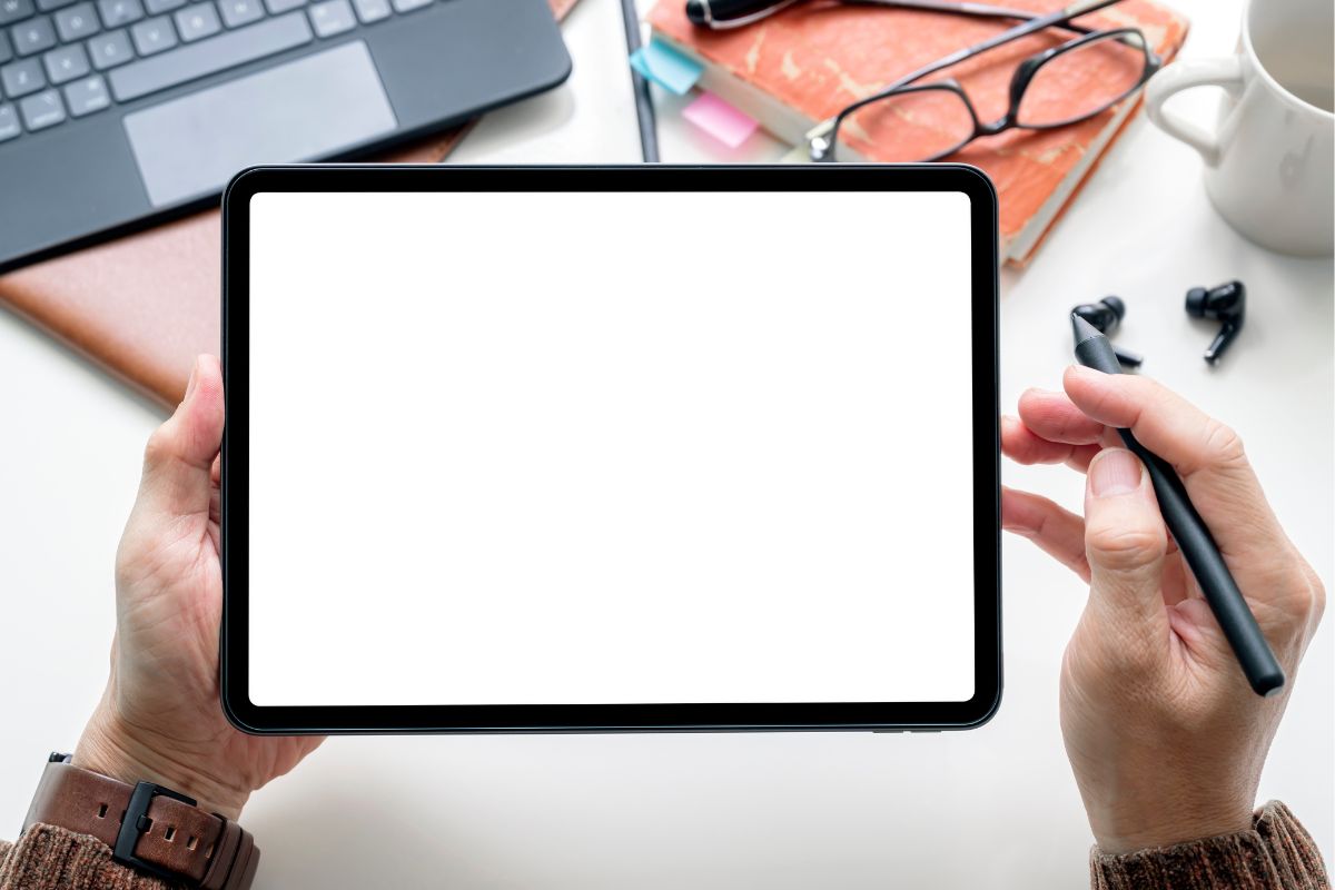 A picture shows a man's hand using a tablet device.