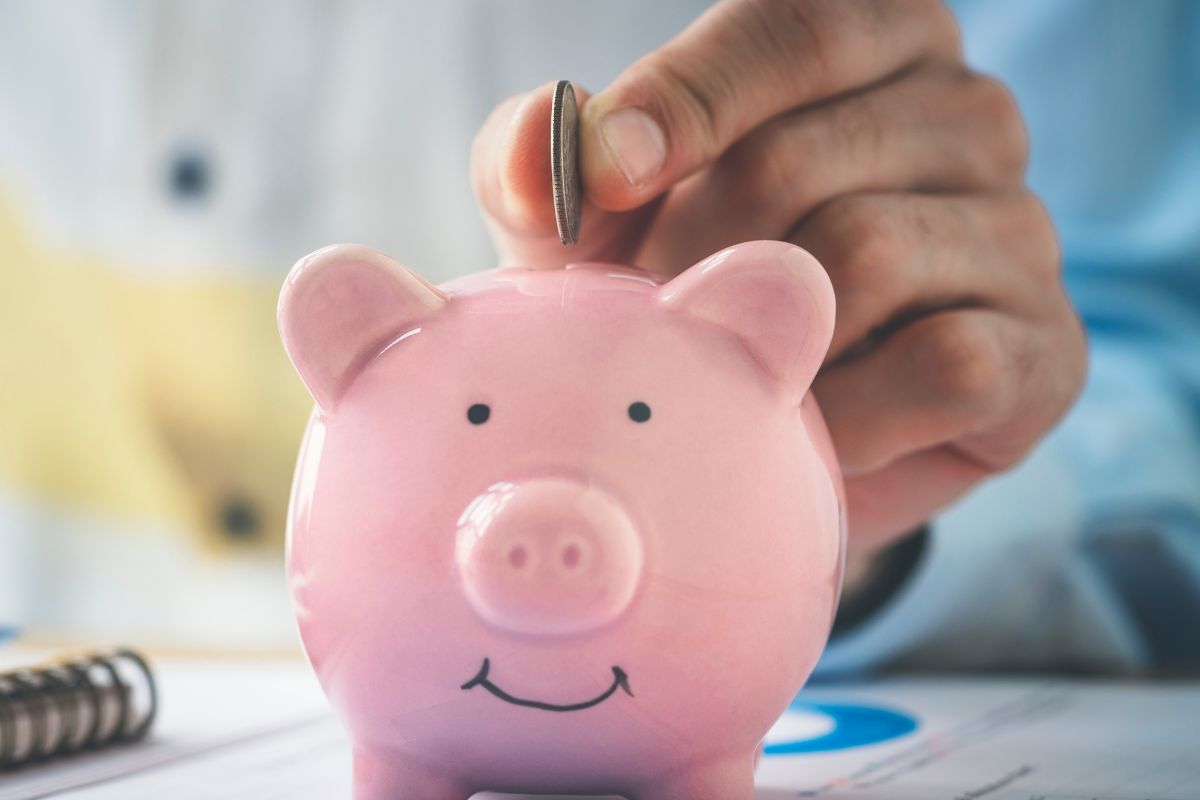 Une image montre une main d'homme économisant de l'argent.