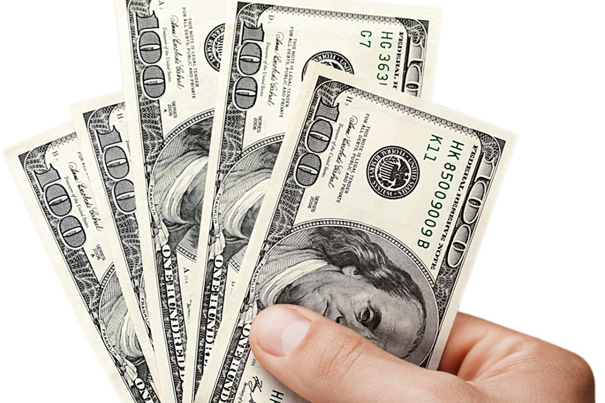 Une image montre une main d'homme tenant de l'argent.