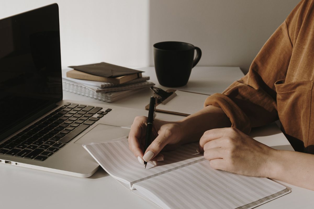 Une image montre une femme écrivant dans un carnet.