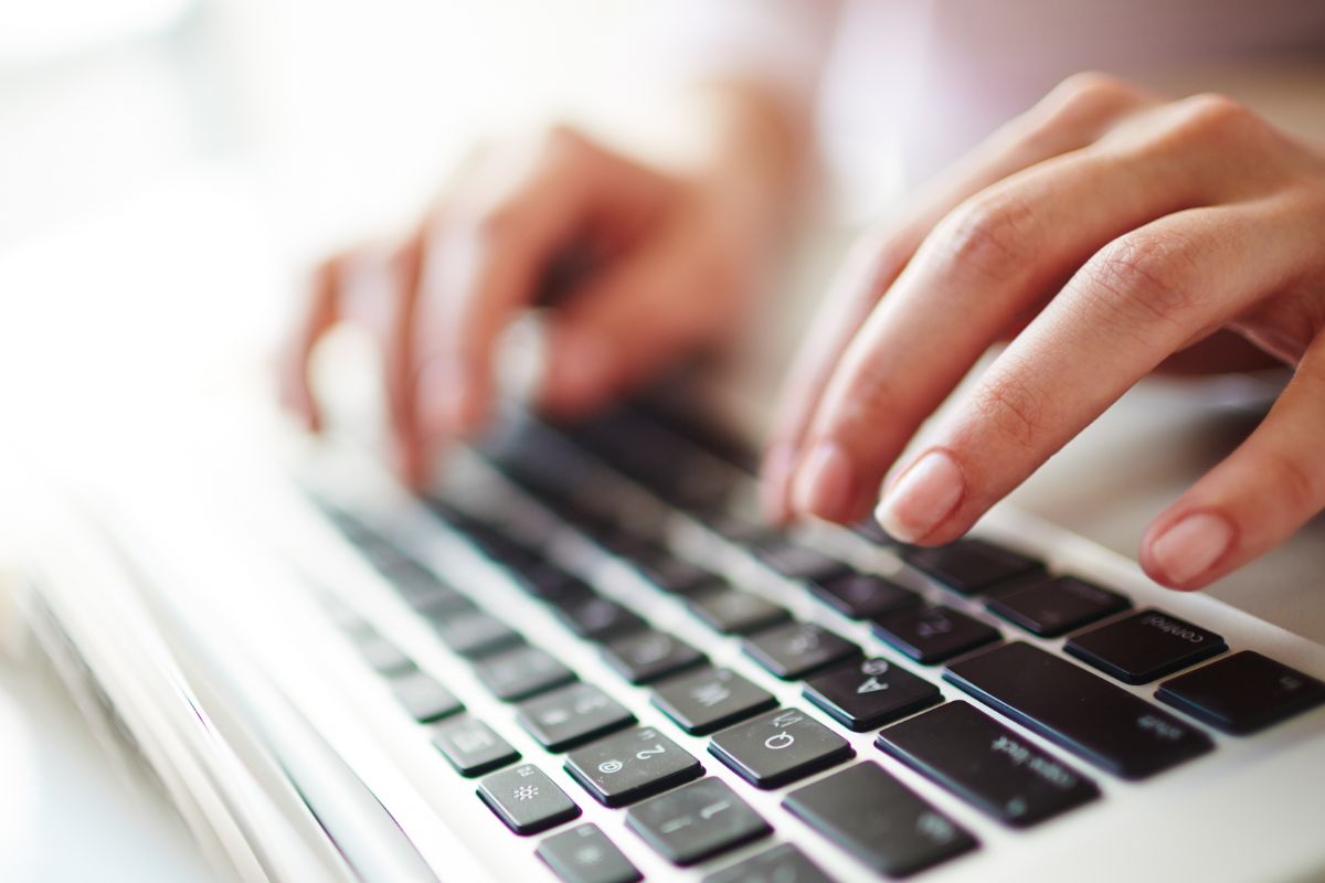 A picture of a woman's hand using a laptop.