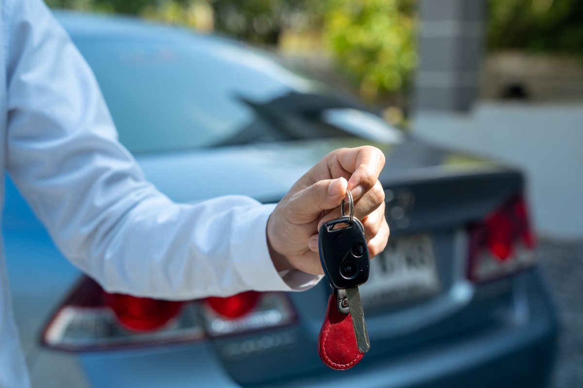 Un homme tenant une clé de voiture.
