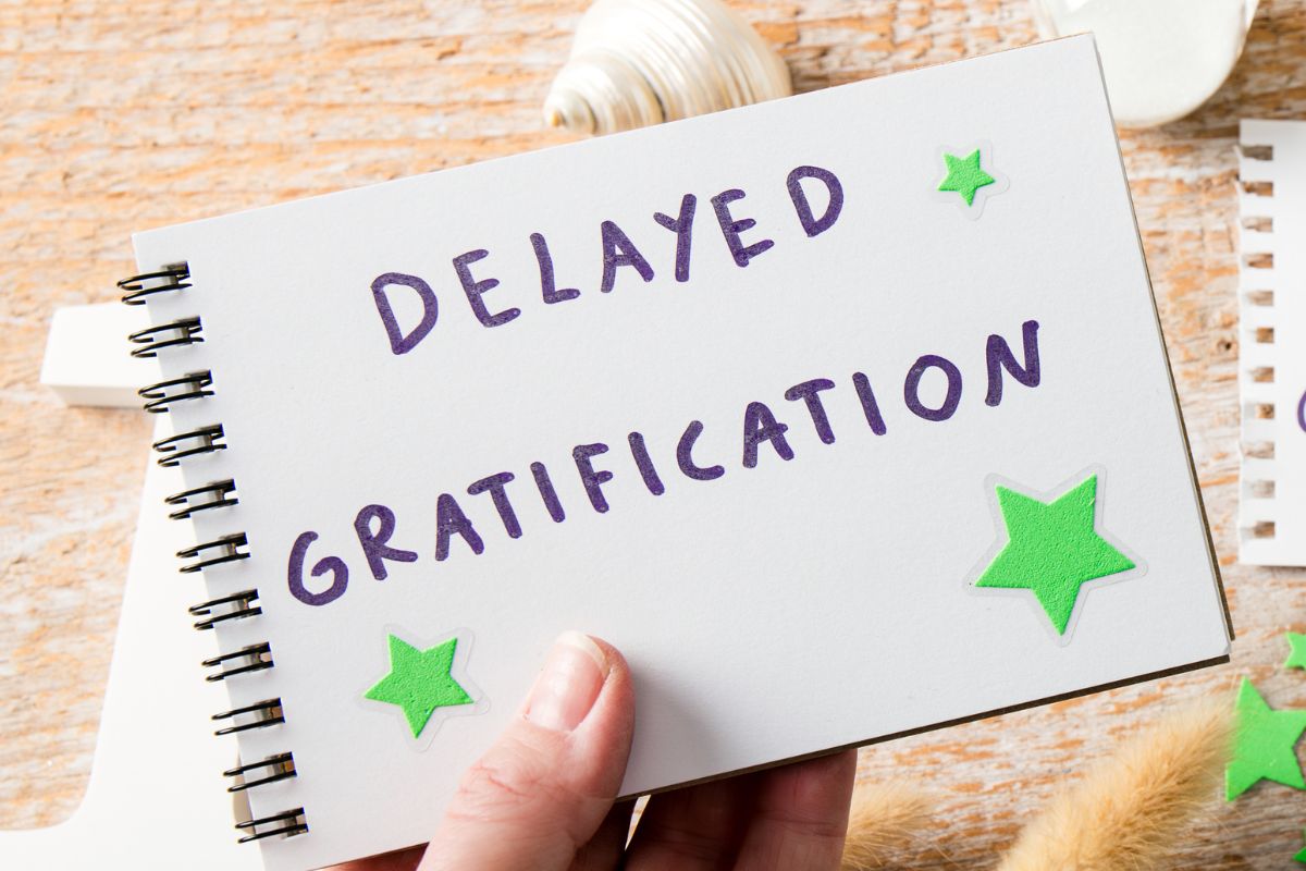 A picture of a notebook with delayed gratification wording.