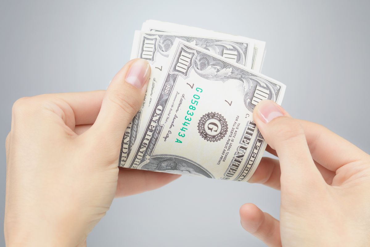 An image of a woman's hand counting money.