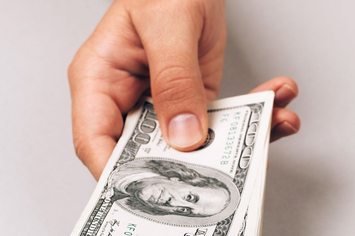 A picture shows a man's hand holding money.