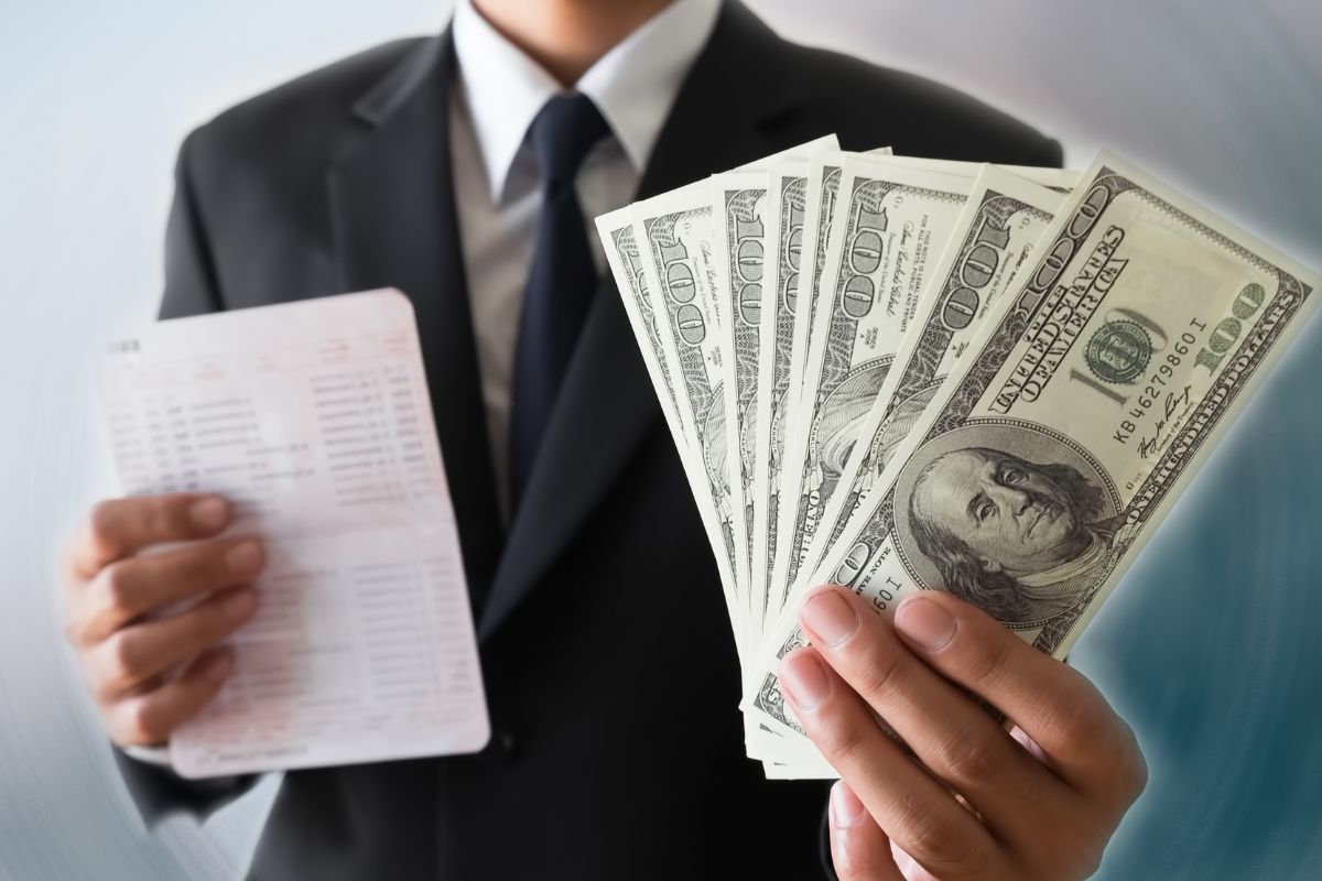 An image of a man in a suit showing money.