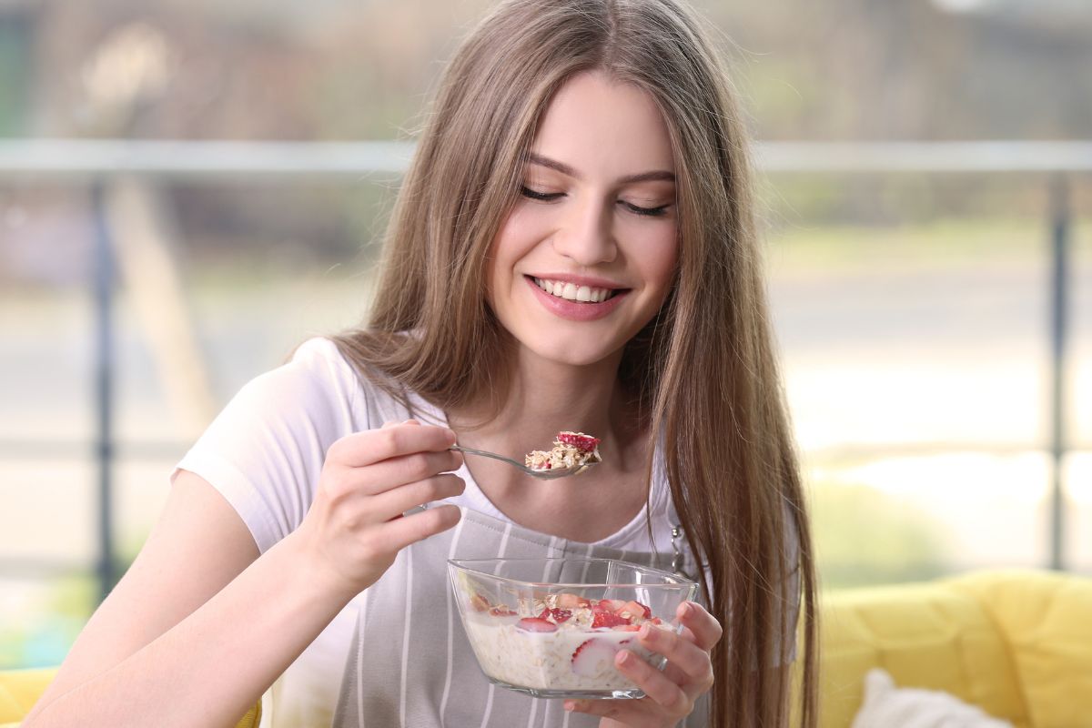 A picture of a woman eating her breakfast.
