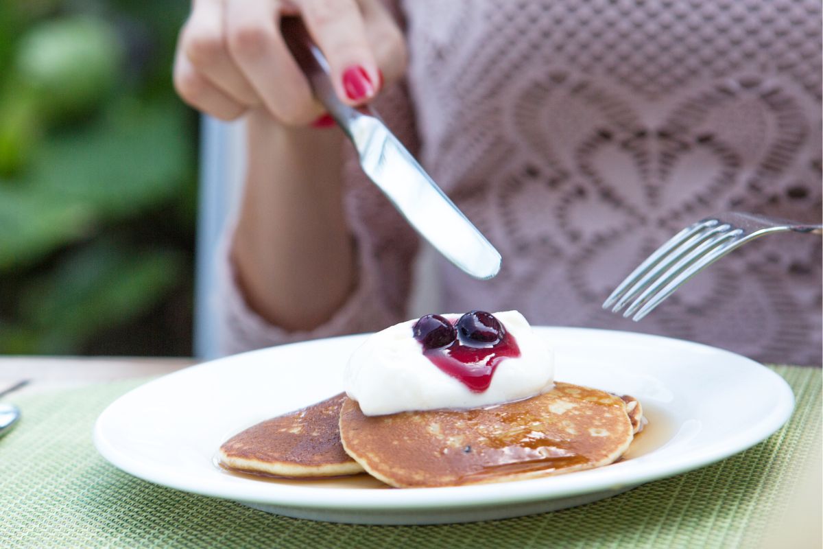 An image of a woman eating a pancake.