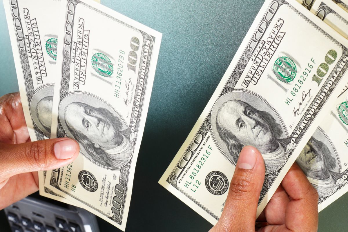 A picture shows a man's hand separating the money.