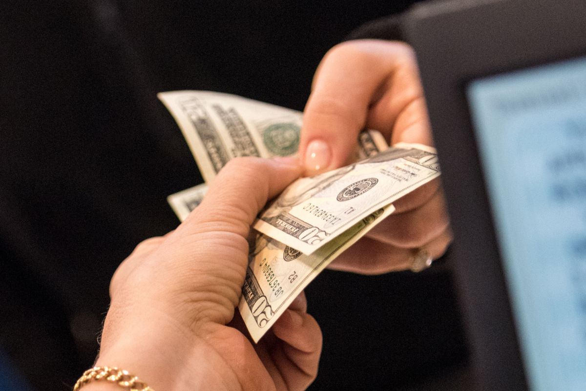 An image of a woman's hand paying with cash.