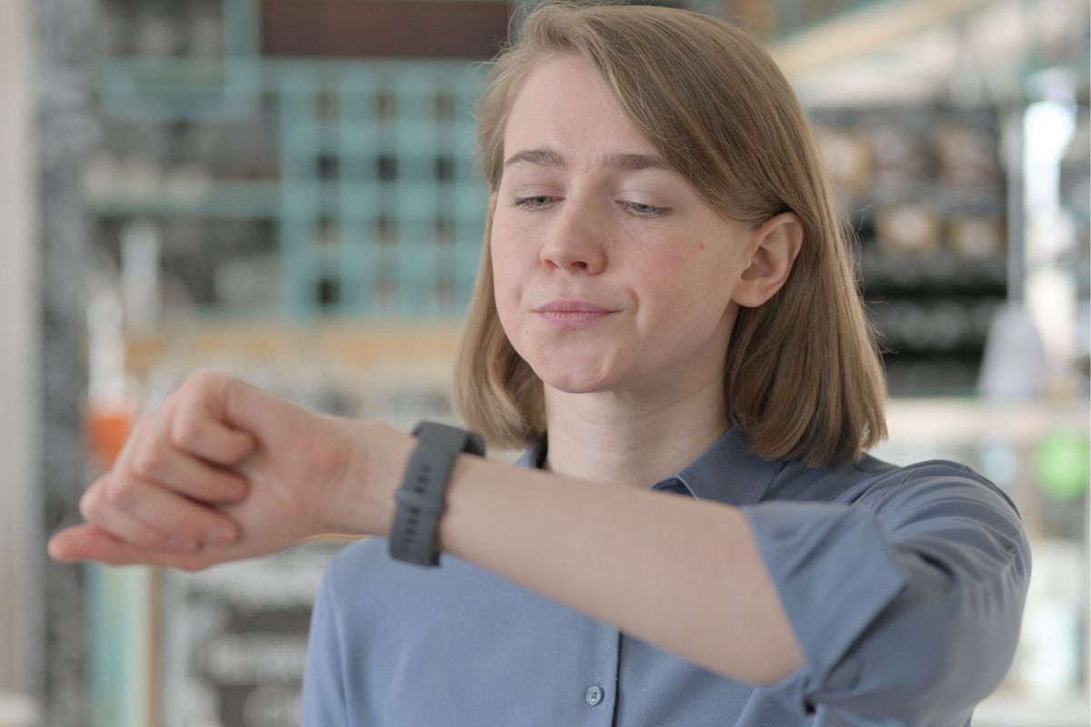 A picture shows a woman checking her watch.