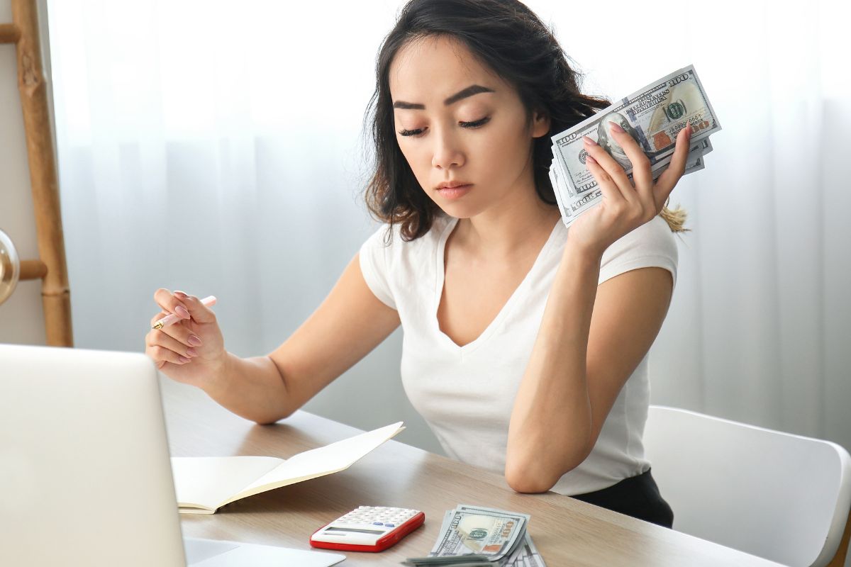 An image shows a woman budgeting her money.