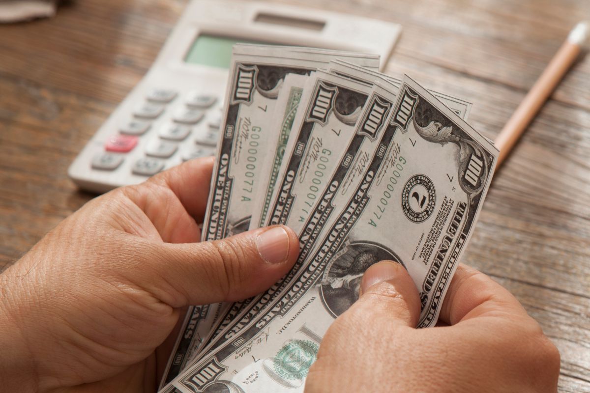 A picture shows a man's hand counting money.
