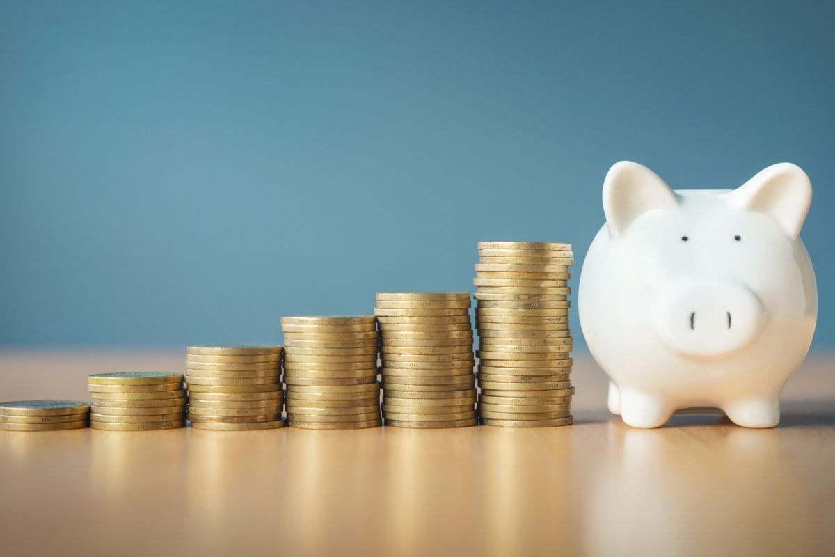 A picture shows a stack of coins and a piggy bank.