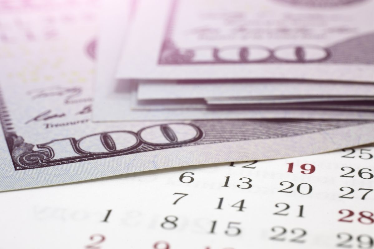 An image shows a calendar and money.