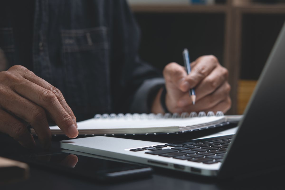 An image of a man taking notes.