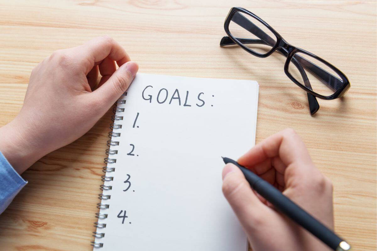 A picture shows a woman writing her goals.