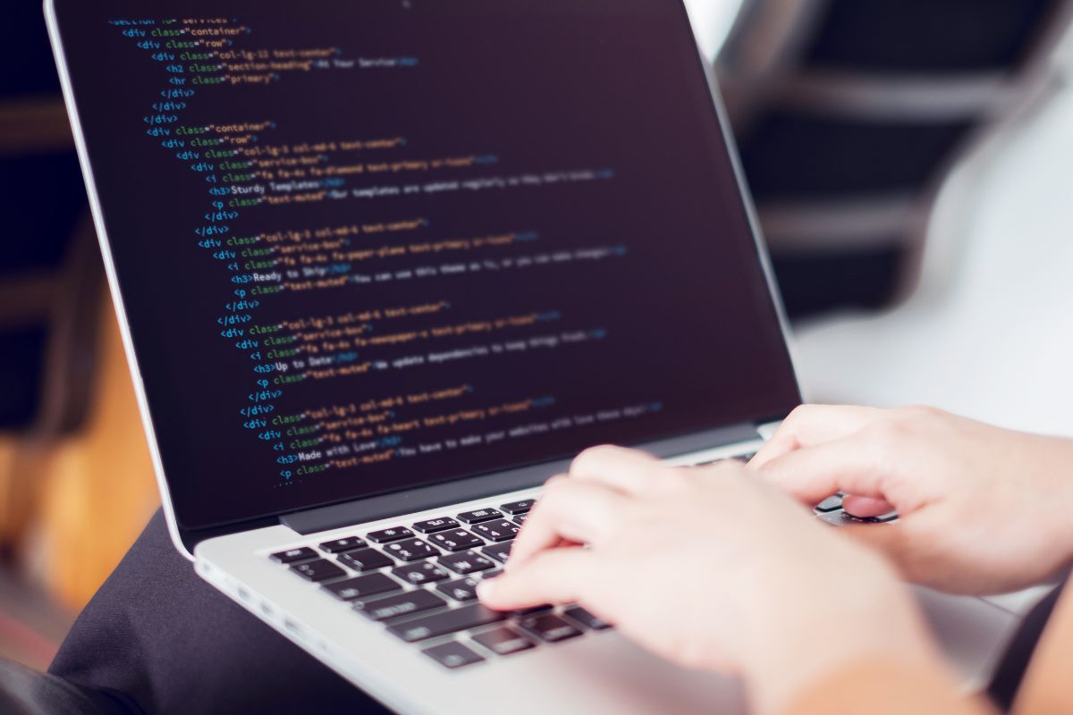 A picture shows a woman coding on her laptop.