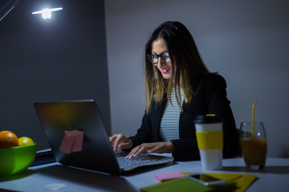 An image shows a woman working at night.