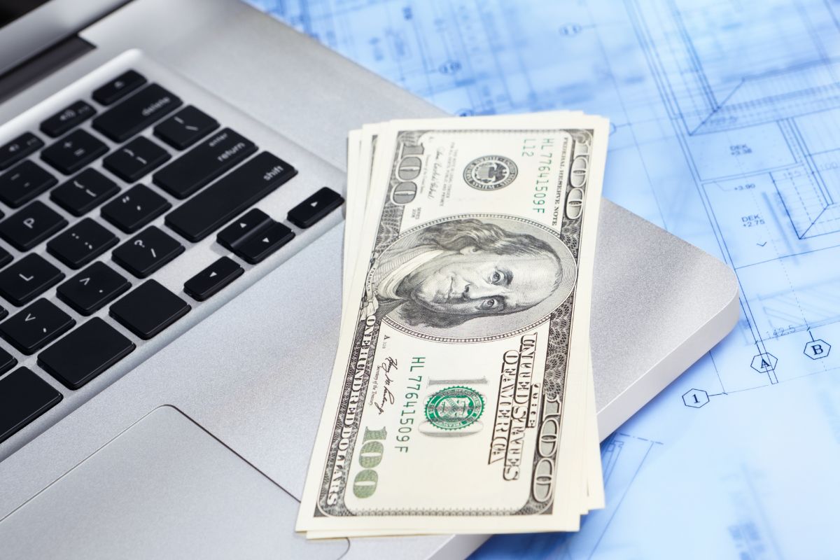 A picture shows a laptop and money.