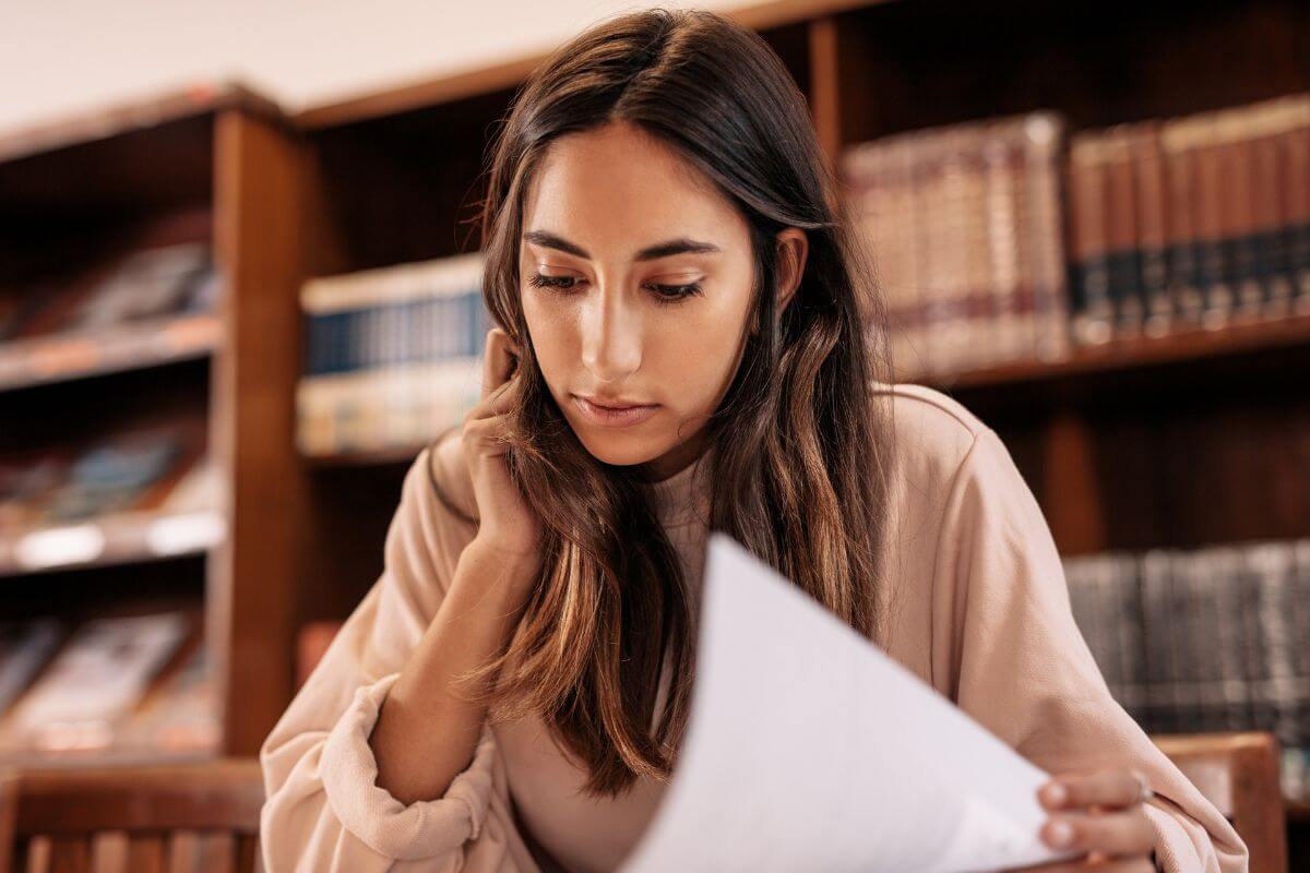 A picture shows a woman reviewing a paper.