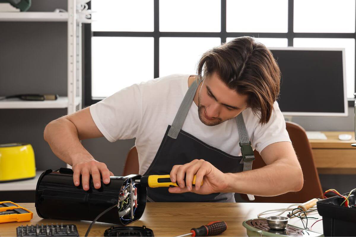 A picture of a man repairing something.