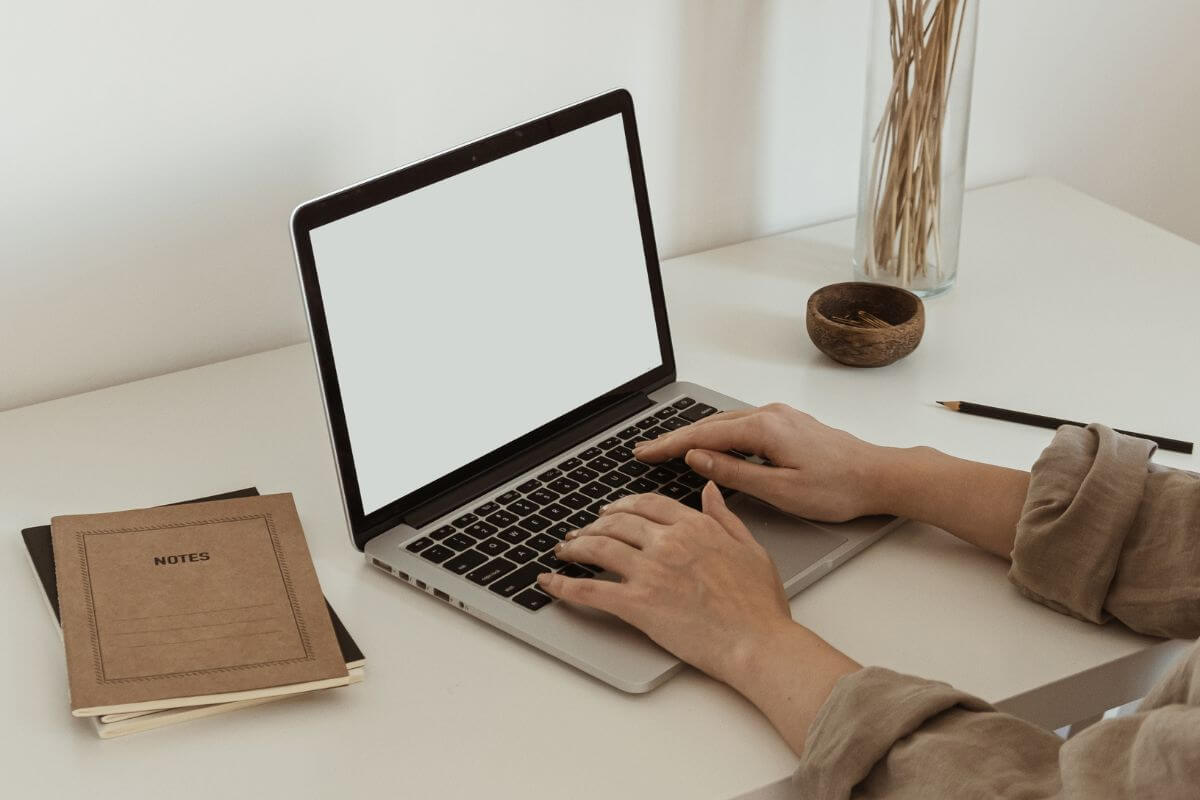 A picture shows a woman's hand using a laptop.