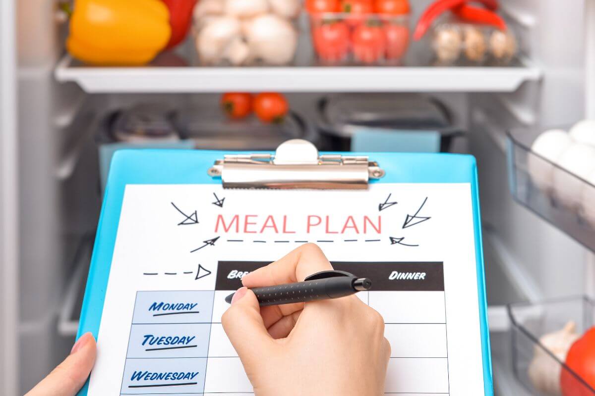 A picture shows a woman making a meal plan.