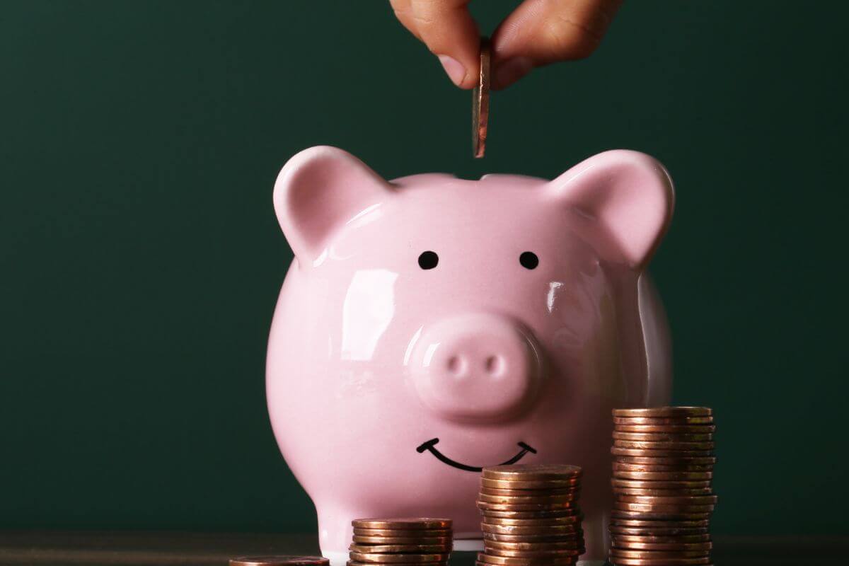 An image shows a man's hand saving money.