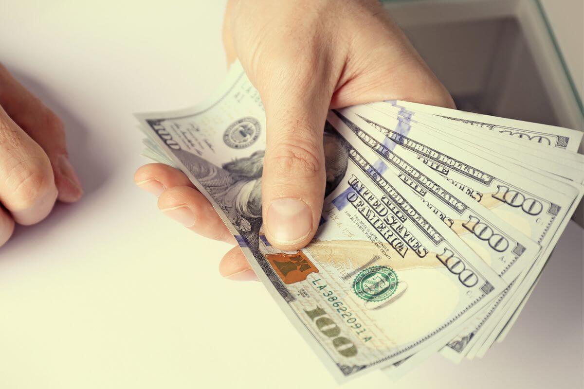 A picture shows a man's hand holding money.