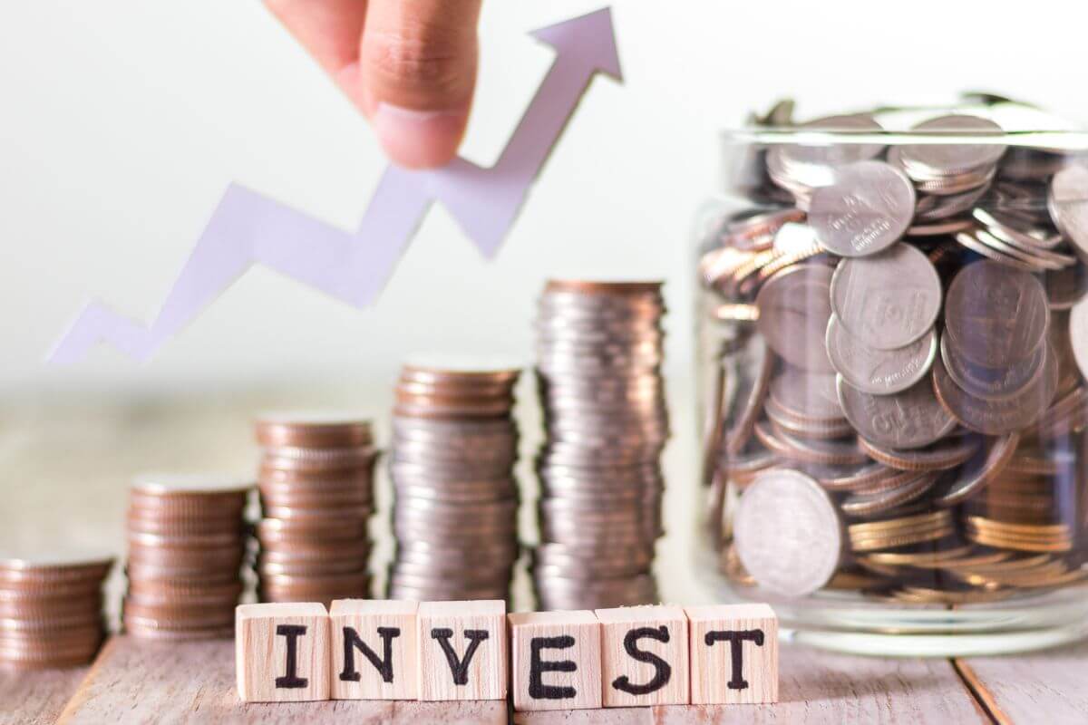 A picture of money and invest wording.