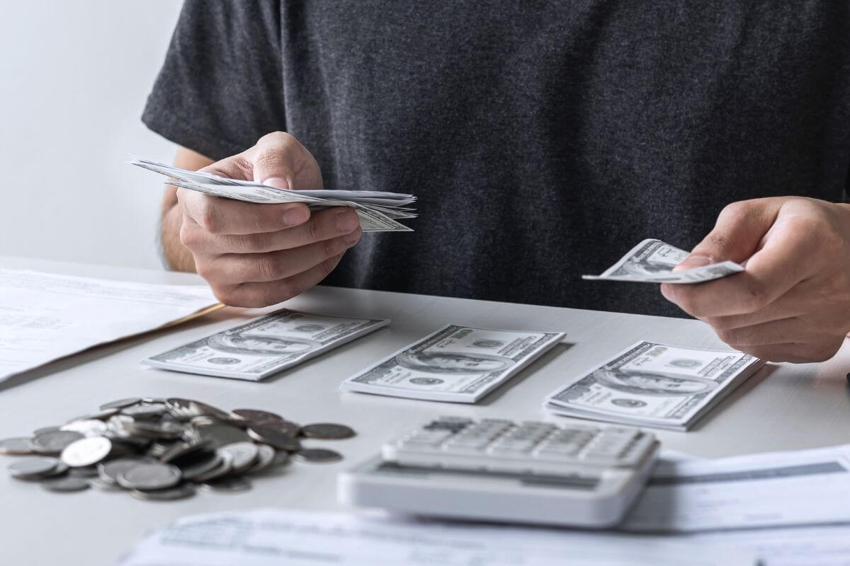 An image shows a man budgeting his money.