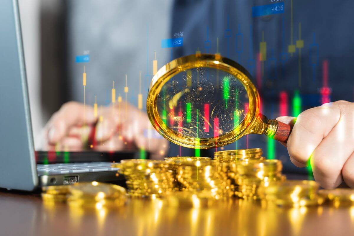 A picture of a man magnifying the gold coins.