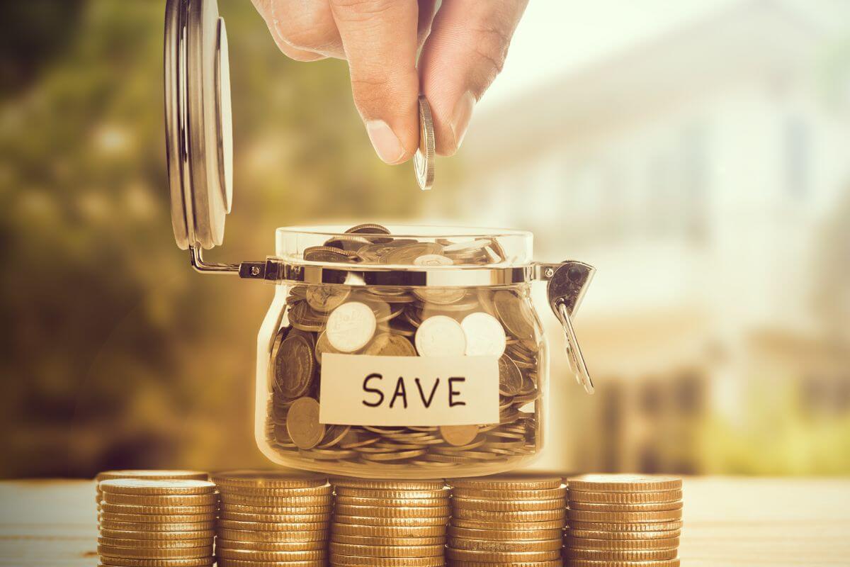 An image shows a man's hand saving money.