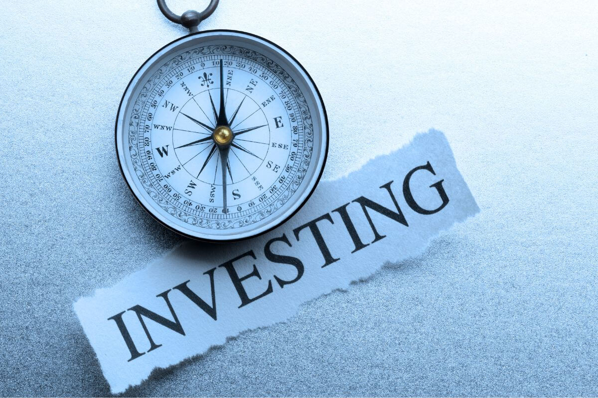 An image of a compass and investing wording.