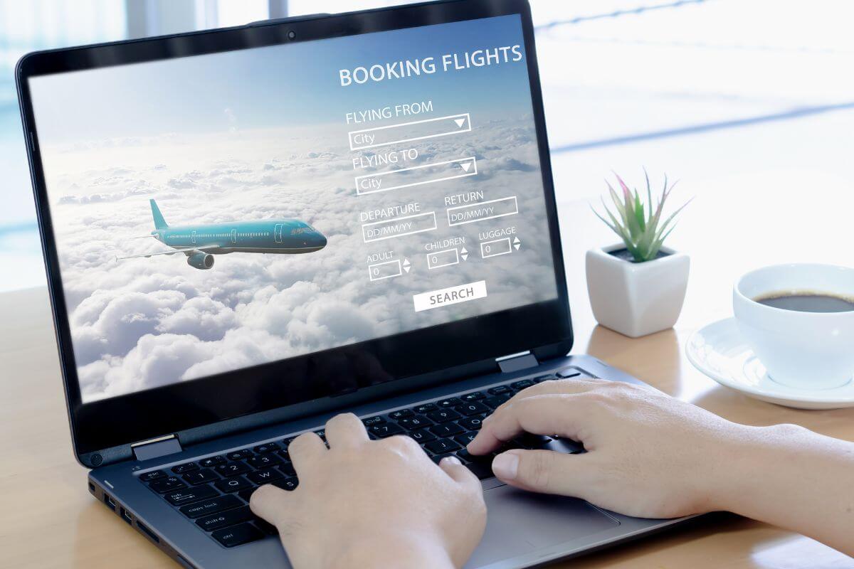 A picture of a woman's hand booking a flight online.