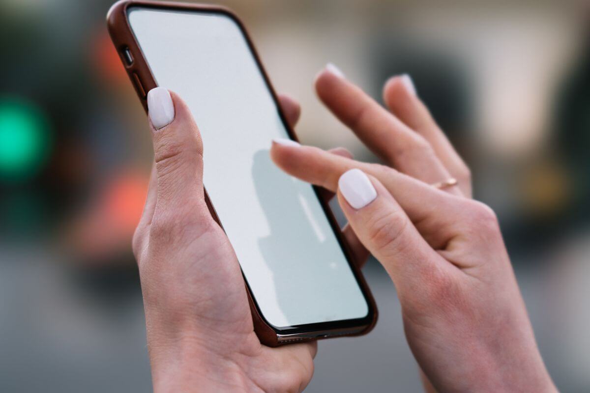 An image shows a woman's hand using a phone.