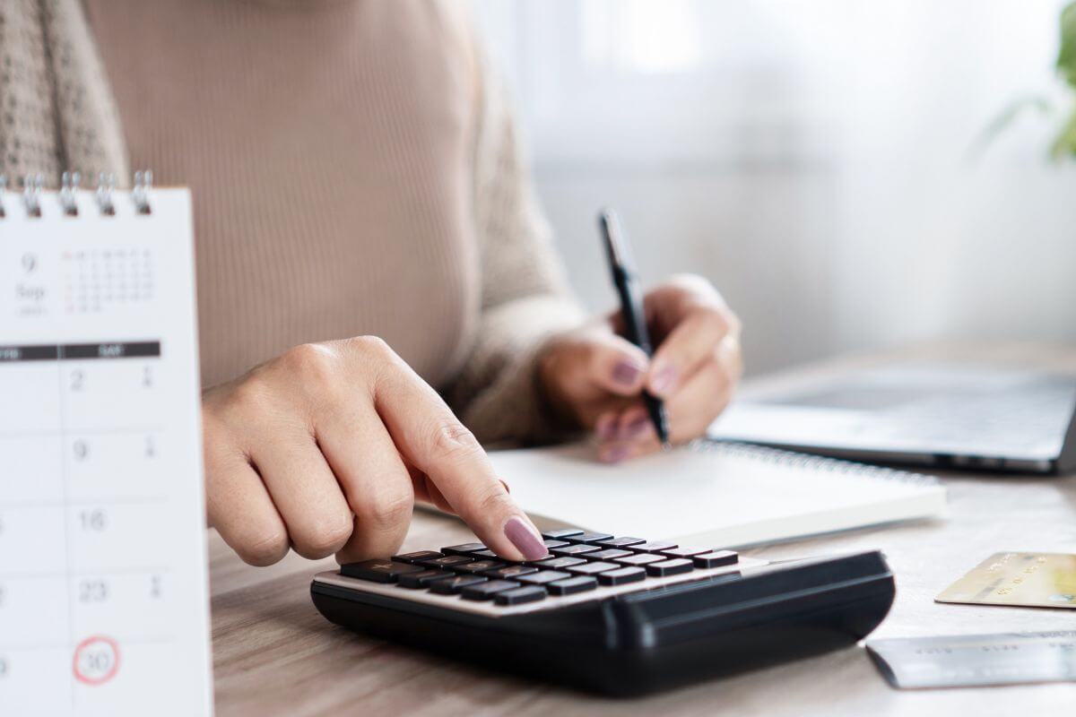 A picture of a woman calculating her expenses.