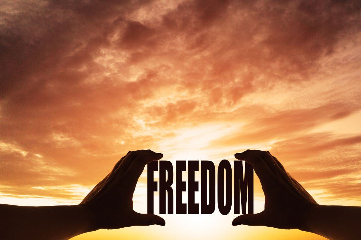 Picture of the word freedom with a beautiful orange sunset.