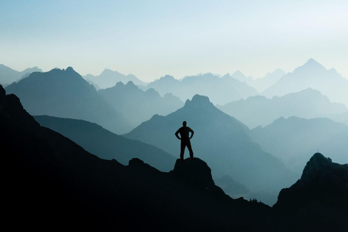 A picture of someone at the summit of a mountain.