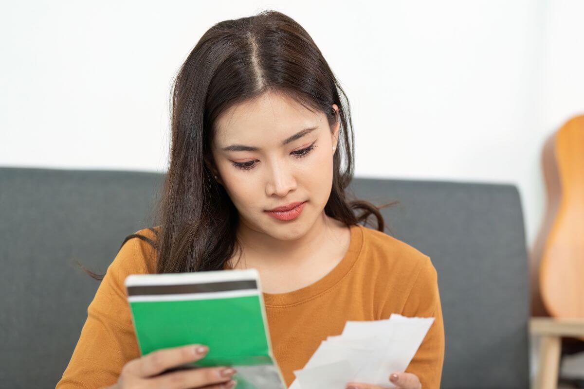 A picture of a lady looking at her money. 