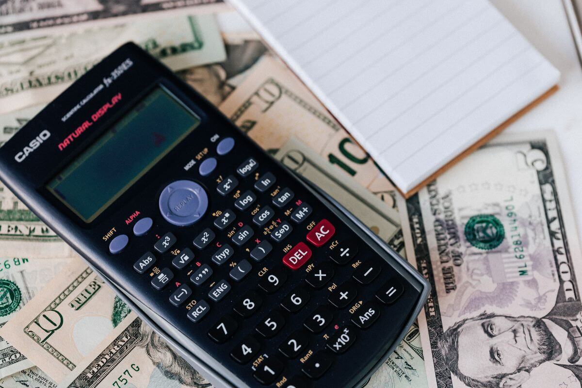 A picture of a calculator, a paper, and money.